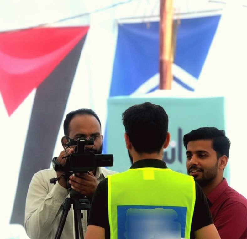 Zaid Ali giving media interview as humanitarian volunteer during Alkhidmat Foundation Gaza relief ration packing drive Karachi Pakistan